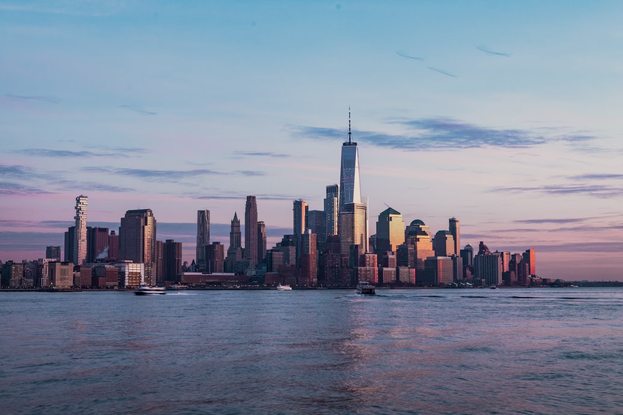 New York City skyline at dusk with One World Trade Center from across the Hudson