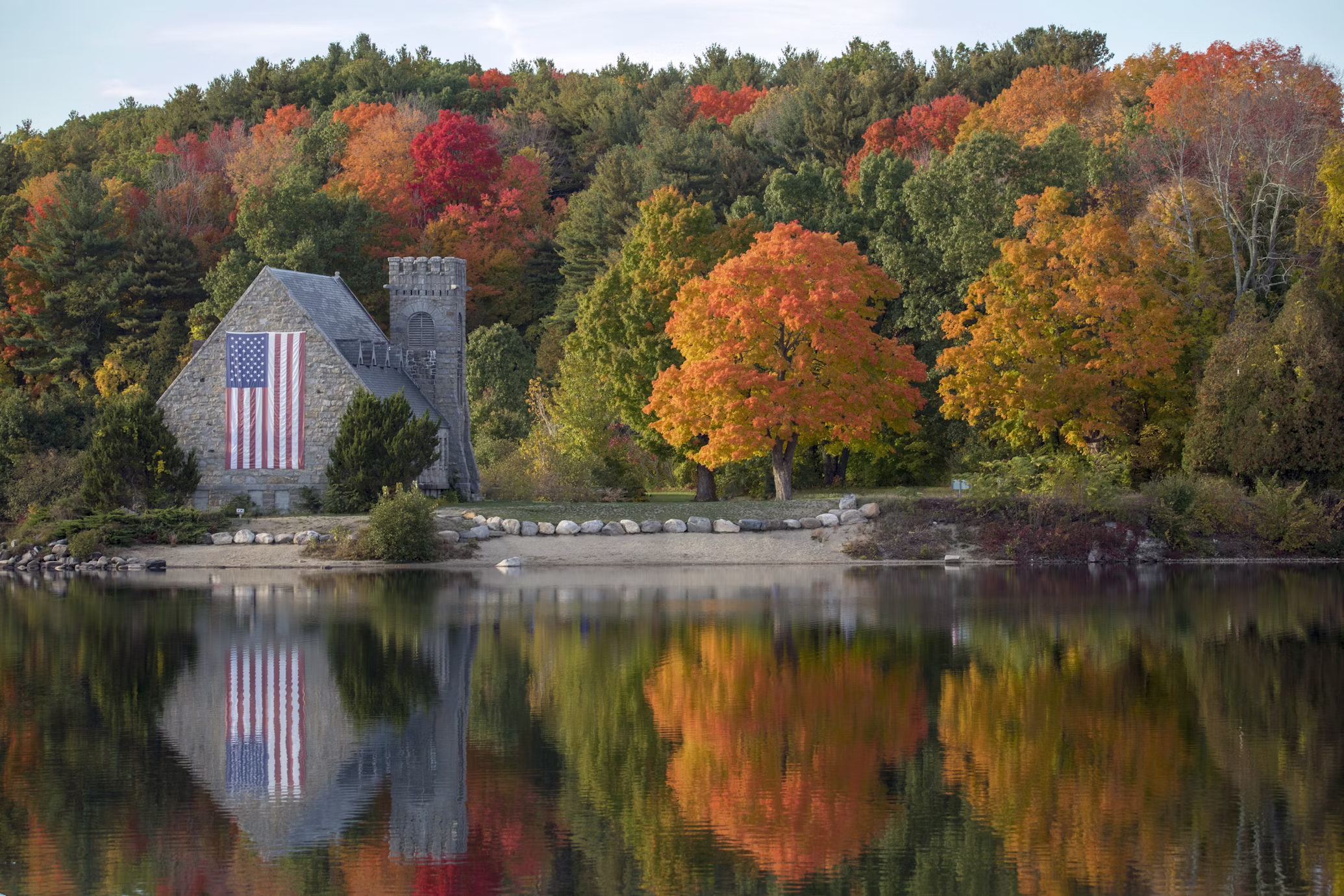 Stone building and autumn foliage reflected in a calm lake