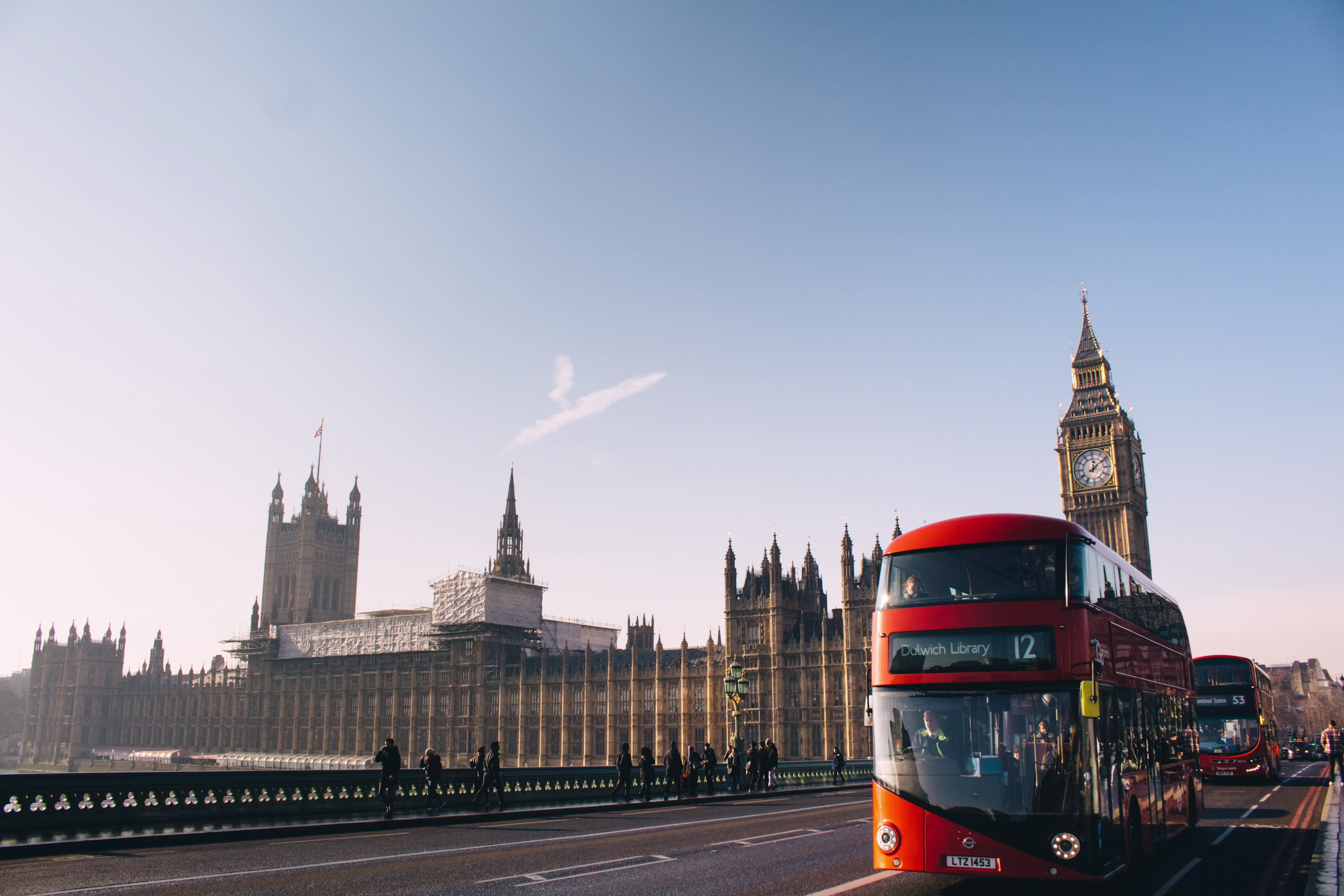 Big Ben and the Palace of Westminster viewed across the Thames with a London bus, London, United Kingdom